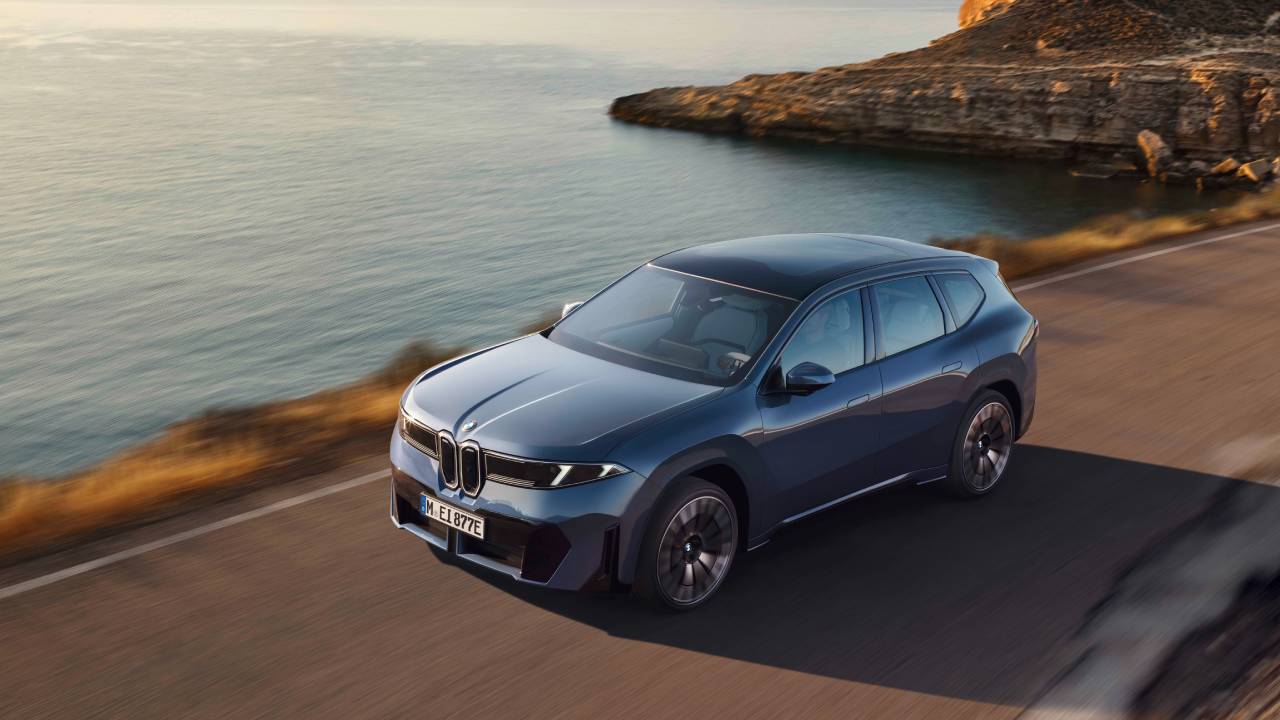 Harmaa BMW iX3, kuvattuna edestä viistosti auringonlaskun aikaan.